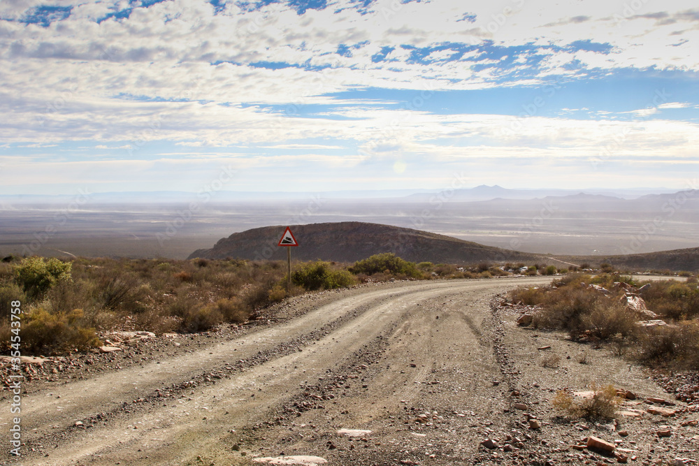 Dirt road or pass dropping into desert Dirt road or pass dropping into desert