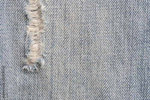 Old torn blue jeans texture close up, top view. Denim background