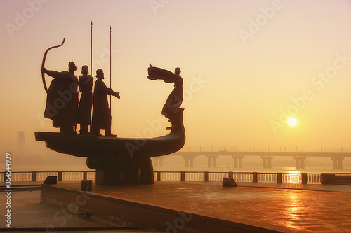 Monument of the mythical founders of Kiev on the Dnieper River in the morning photo