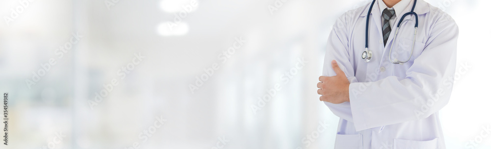 Portrait of Asian medical male Doctor standing in front of his blurred interior hallway in hospital banner background.Concept of effective work in hospitals. Portrait of Asian medical male Doctor standing in front of his blurred interior hallway in hospital banner background.Concept of effective work in hospitals.