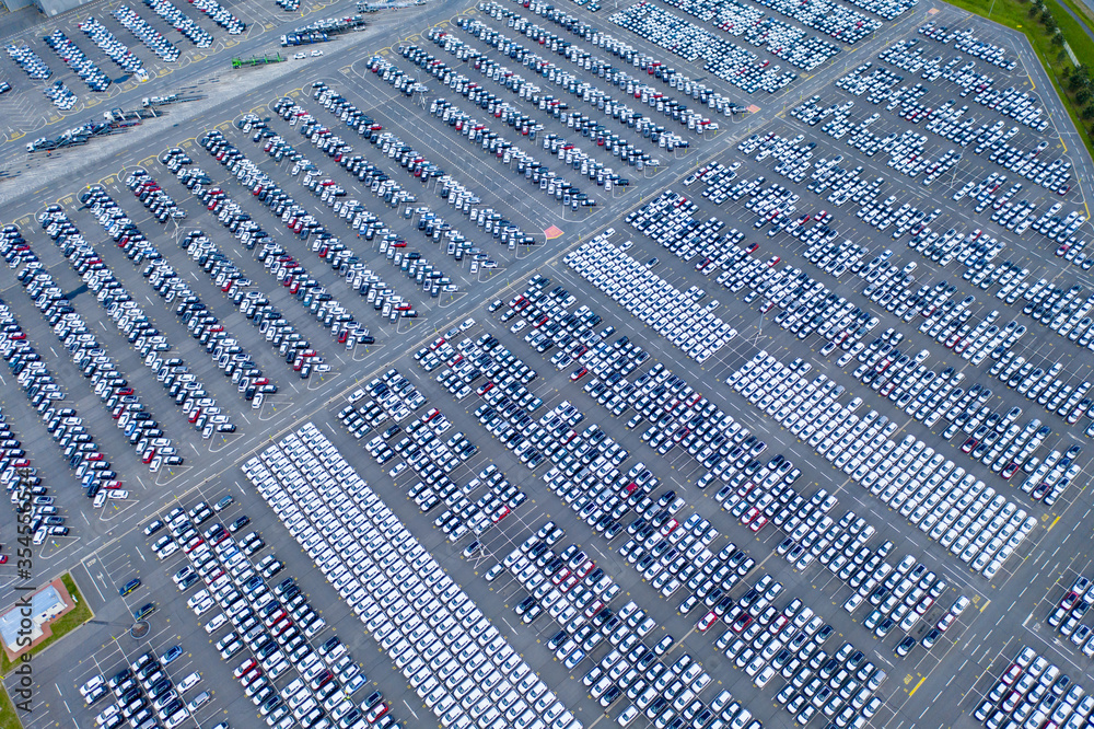 Aerial top view photo from flying drone, New Cars produced Several times a year at industrial estate for import export around in the world at night.
