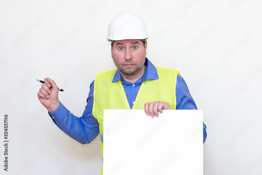 Portrait of middle-aged handsome worker wearing white helmet holding pen blank paper sheet for text. white studio background Portrait of middle-aged handsome worker wearing white helmet holding pen blank paper sheet for text. white studio background