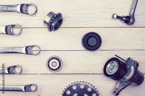 The layout of auto parts and car repair tools. Wooden white background.