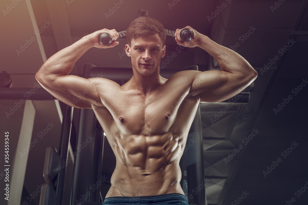 Obraz premium Bodybuilder strong man pumping up abs muscles