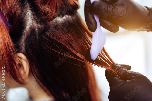 Hairdresser applies a hair mask to the woman in the beauty salon. Botox and keratin hair straightening procedure