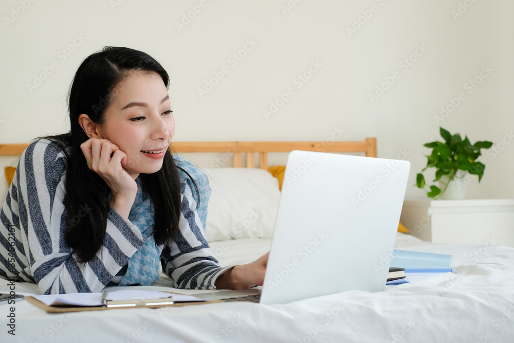 Asian business woman using computer laptop work from home on bed. Asian business woman using computer laptop work from home on bed.