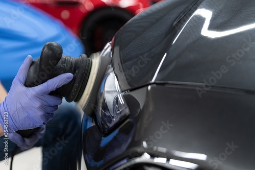 Bilde på lerret Man worker of car detailing studio polishing and renovating car headlamp