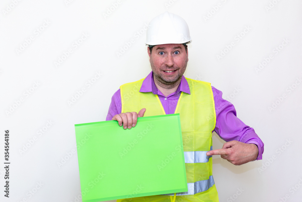 Portrait of curious surprised architect in a construction helmet holding a folder, free place mock up banner advertisement.Studio shoot. Portrait of curious surprised architect in a construction helmet holding a folder, free place mock up banner advertisement.Studio shoot.