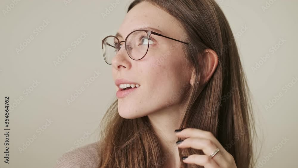 Young smiling woman isolated over grey wall background Young smiling woman isolated over grey wall background