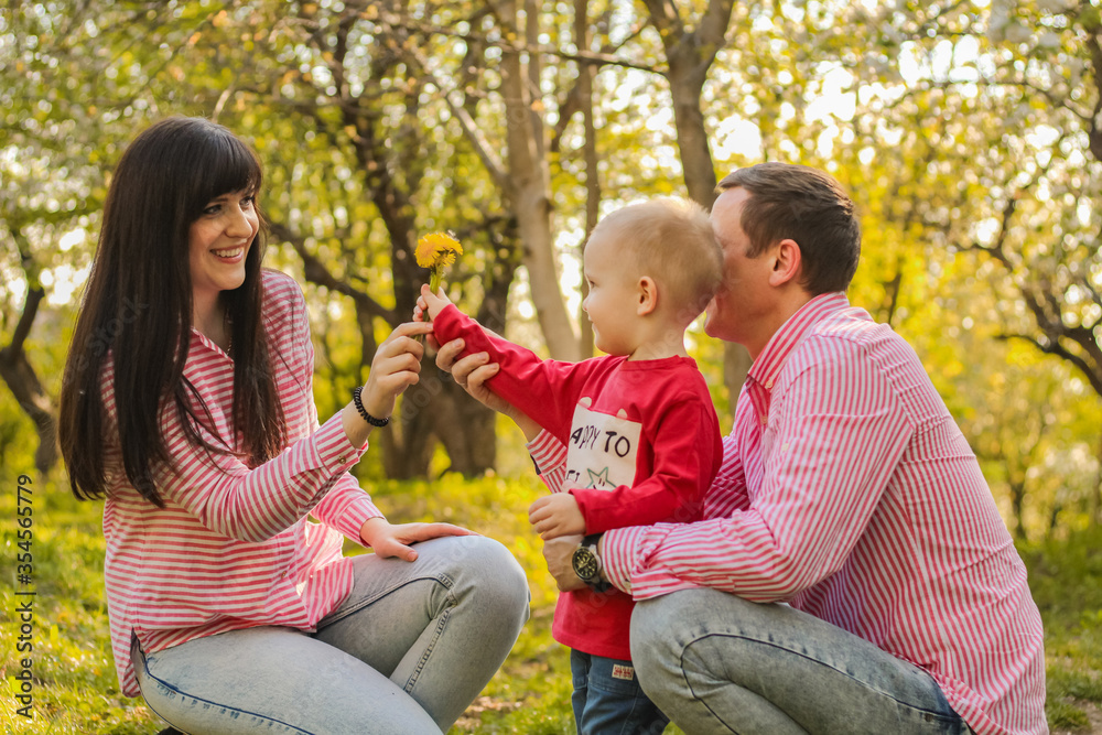 happy young family having fun outdoors. a little boy  with his father give flowers for mother