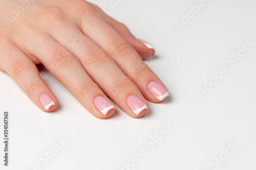 Beautiful female palm with french manicure on white