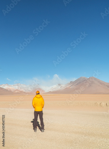 Wallpaper Mural  Tourist man hiking landscape mountain lake. Dry, Barren desert, snowcapped mountains wilderness. Mountain range view. Salt Flats, Uyuni, Bolivia. Copy space, Rocks, blue sky, nature, hiker Torontodigital.ca