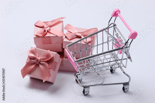 Supermarket trolley with gift boxes on a white background