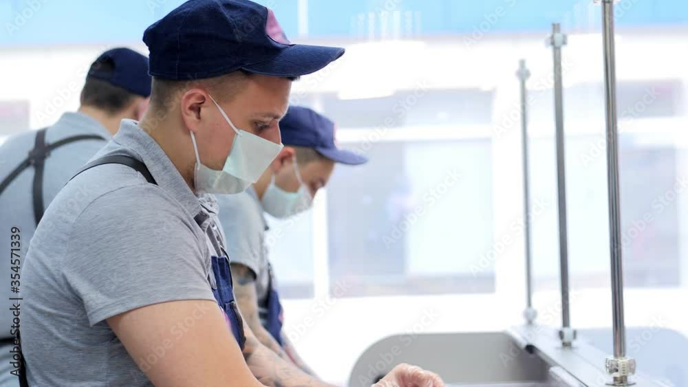 Portrait of a sushi chef wearing face mask in the commercial kitchen. Take away food Portrait of a sushi chef wearing face mask in the commercial kitchen. Take away food