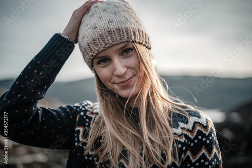 Portrait of young smiling woman wearing a handmade knitted hat
