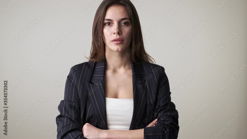 A displeased serious woman is shaking her head with negative expression standing isolated over white background in studio A displeased serious woman is shaking her head with negative expression standing isolated over white background in studio