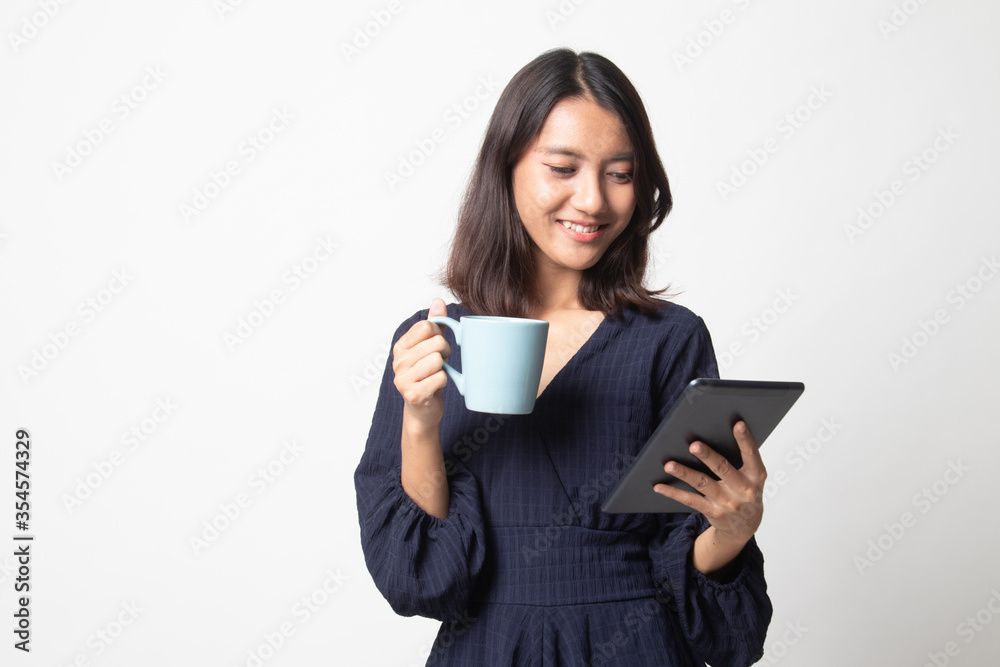 Young Asian woman with a computer tablet and coffee. Young Asian woman with a computer tablet and coffee.