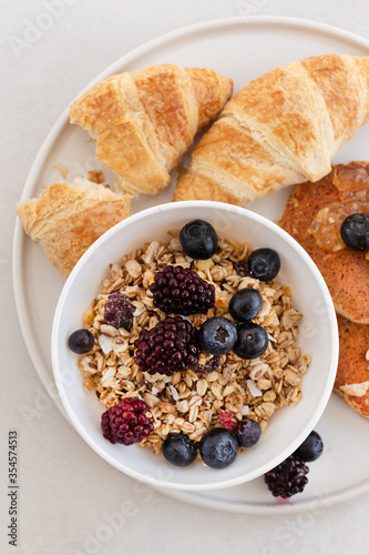 Topview image of yummy breakfast. Granola with berries, croissan photo