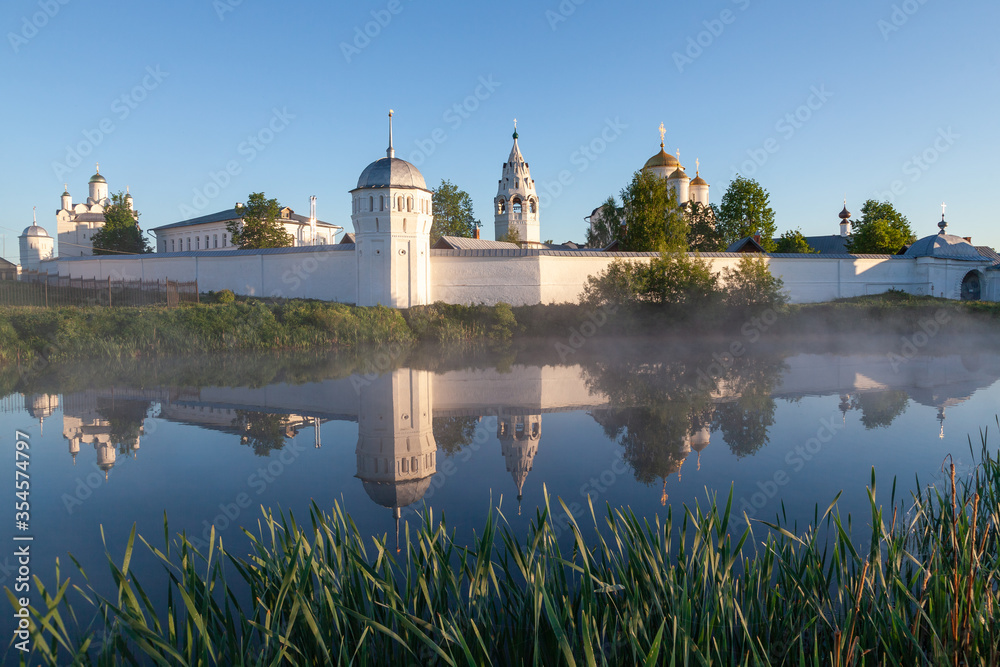 The architectural ensemble of the Suzdal Intercession Convent and reflection in the monastery pond in soft fog of early spring morning, the Golden Ring of Russia