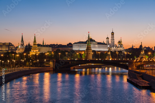 Classic view to the Moscow Kremlin and Bolshoy Kamenny Bridge above the river at half an hour before dawn with blue sky and bright orange horizon