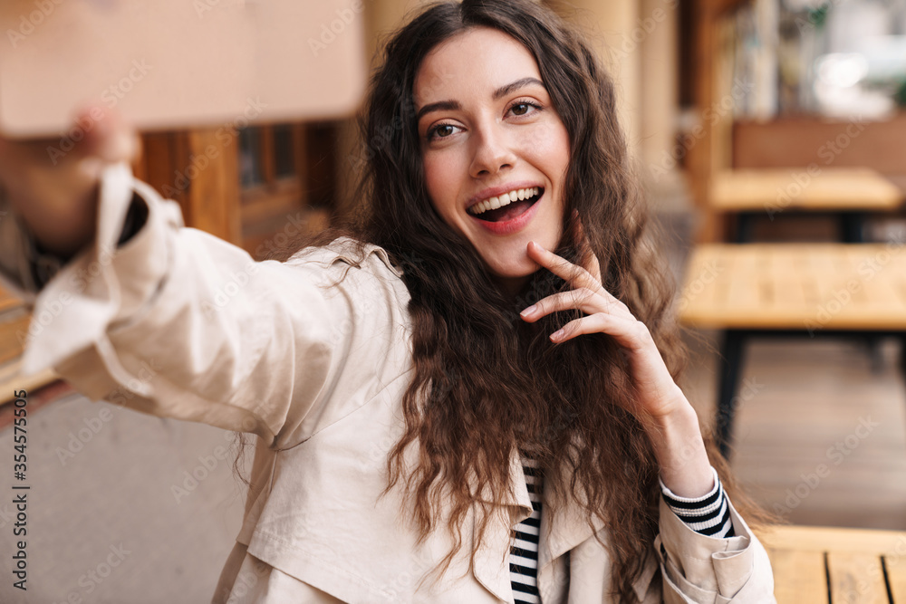Image of happy woman taking selfie photo on cellphone and smiling