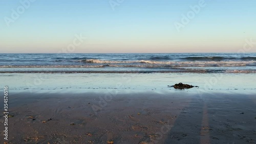 North Sea tide arriving at Seaham Beach in Sunderland, Tyne and Wear, England UK with a pile od seaweed in the foreground - 4k Video.