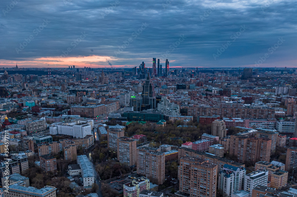 Night Moscow with epic clouds from above, skyscrapers and business centers, houses of local residents against a cloudy night sky. Aerial photography