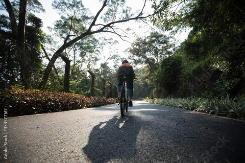 Woman riding on bike path at park on sunny day © lzf