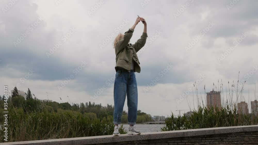 A woman tries to catch a mobile signal by holding up her smartphone