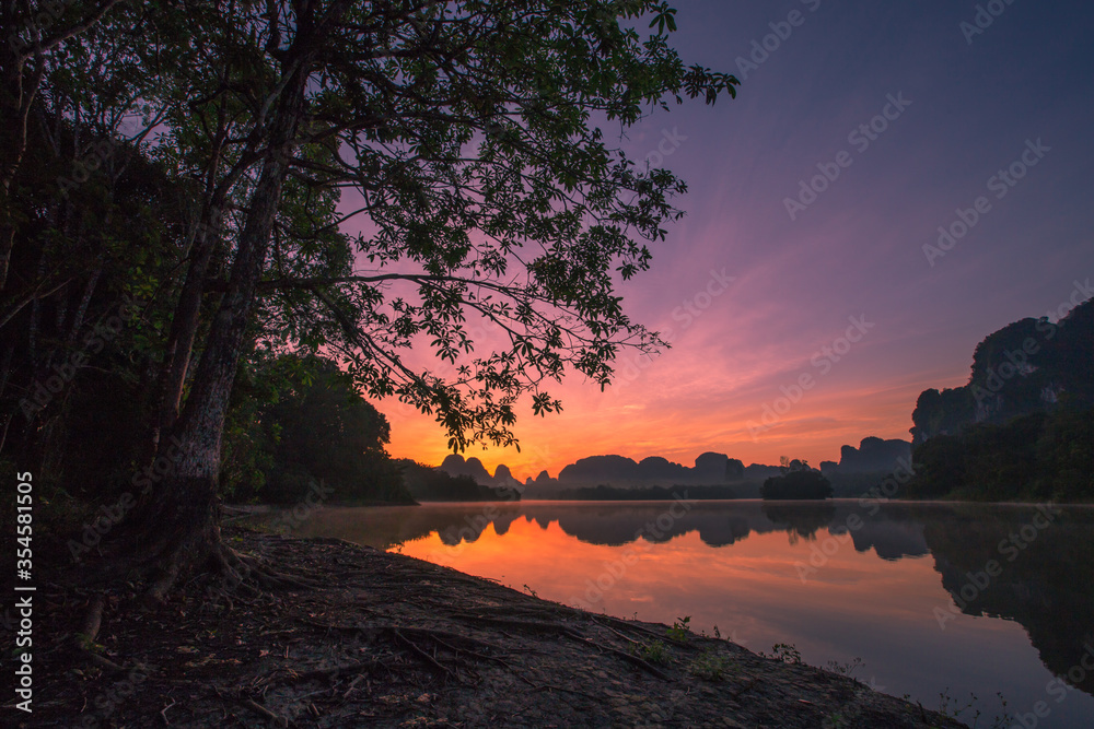 Obraz premium Natural background of a large reservoir in Krabi,Thailand(Nong Thale)atmosphere surrounded by mountains,trees of various sizes, blown through the wind,blurred cool during the day,a viewpoint of travel