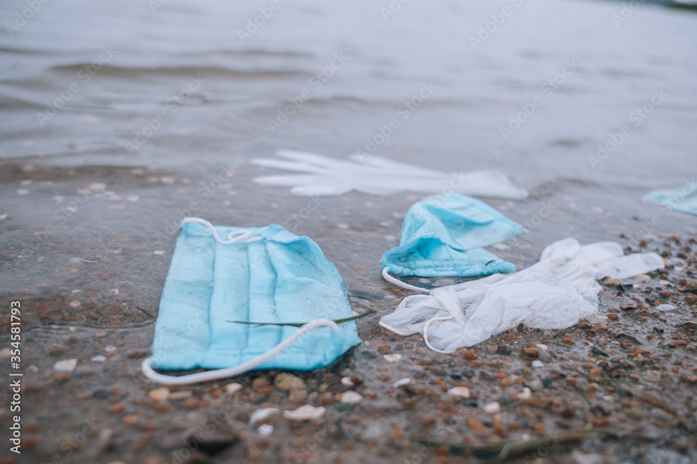 garbage from used medical masks and gloves on the beach and in the water garbage from used medical masks and gloves on the beach and in the water