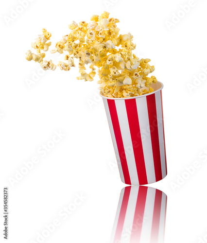 Flying popcorn from paper striped bucket isolated on white background