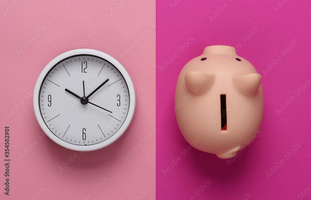 Time to invest. White clock and piggy bank on pink background. Minimalistic studio shot. Top view Time to invest. White clock and piggy bank on pink background. Minimalistic studio shot. Top view