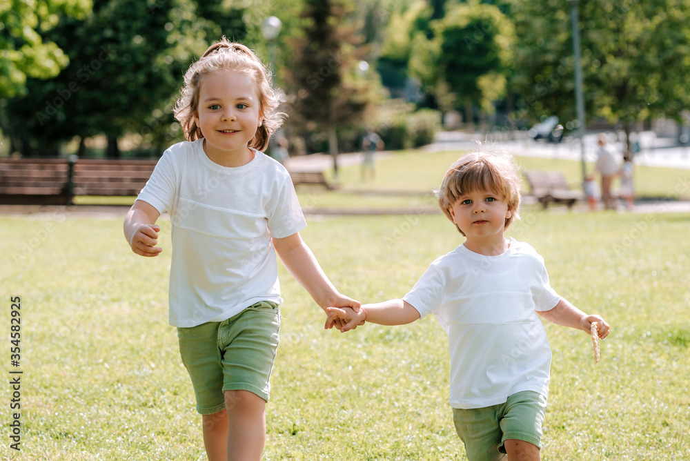 Fototapeta premium Blond children play and have fun on a sunny day in the park..