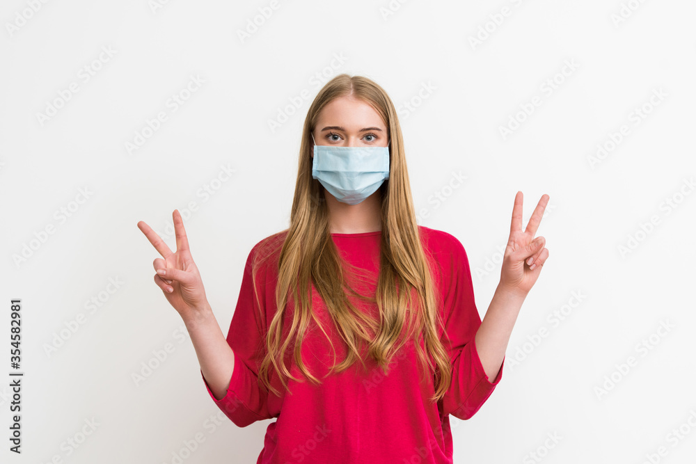 young woman in medical mask showing peace sign isolated on white young woman in medical mask showing peace sign isolated on white