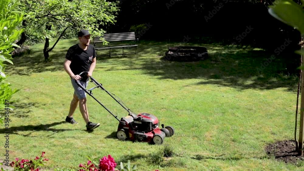 gardener mowing the grass in the backyard. gardener mowing the grass in the backyard.
