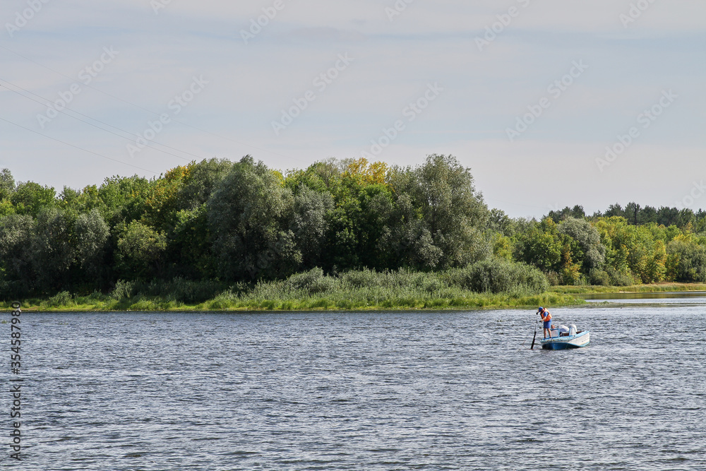 Rescuers on the river in a motor boat in the summer in Belarus.