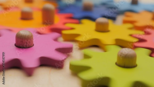 Gears and cogs macro in colorful wooden toy. Team work concept. Connection background. Business concept. Working together. Simple mechanism. Mechanics basics