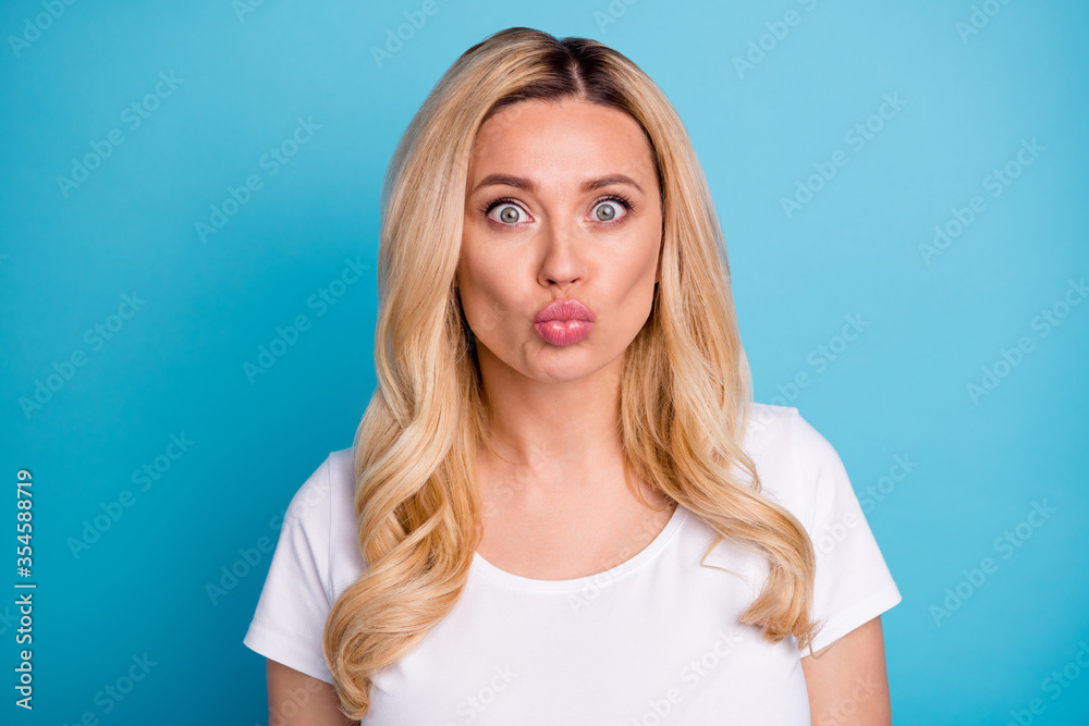 Closeup photo of attractive lady wavy blond hairdo charming appearance send air kisses funny facial expression wear casual white s-shirt isolated blue color background