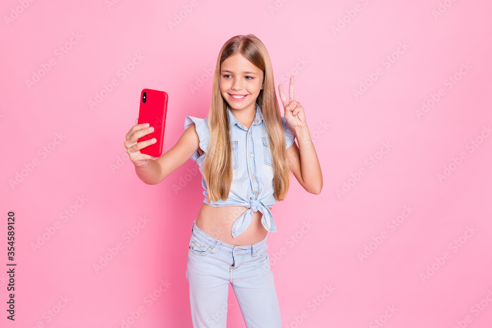 Hey my dear followers. Positive kid girl popular instagram blogger make selfie smartphone show v-sign wear stylish clothes isolated over pastel color background Hey my dear followers. Positive kid girl popular instagram blogger make selfie smartphone show v-sign wear stylish clothes isolated over pastel color background