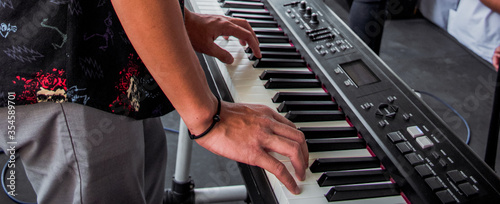 Hand men playing keyboard piano for music event. 