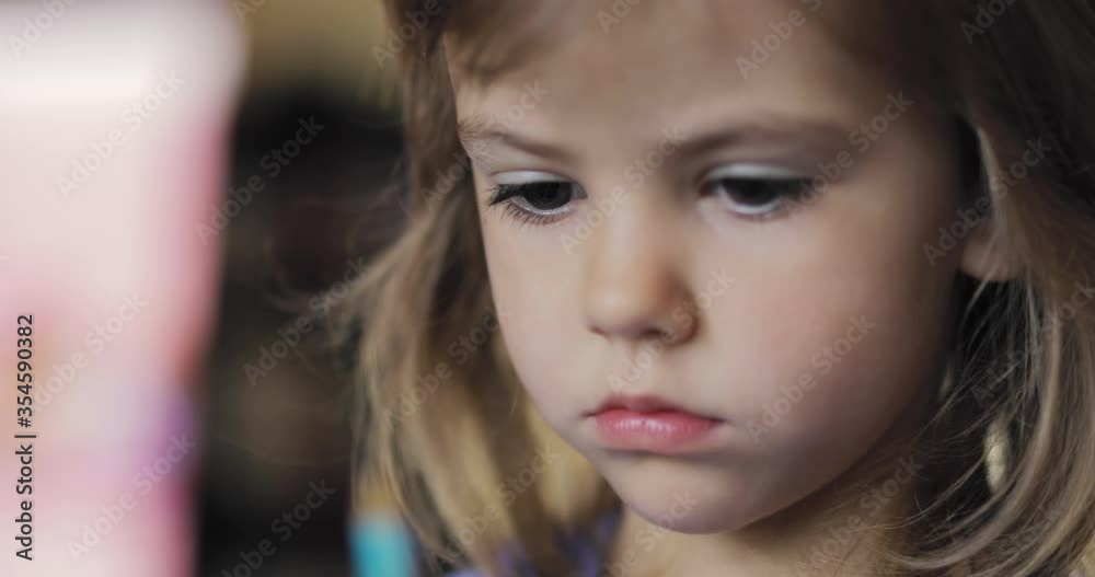 Adorable little girl sitting and playing with a pencil Adorable little girl sitting and playing with a pencil