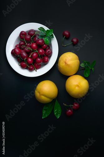 Peaches and cherries on a white dinner plate