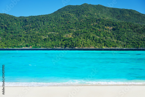 Tropical beach with turquoise clear sea and white sand.