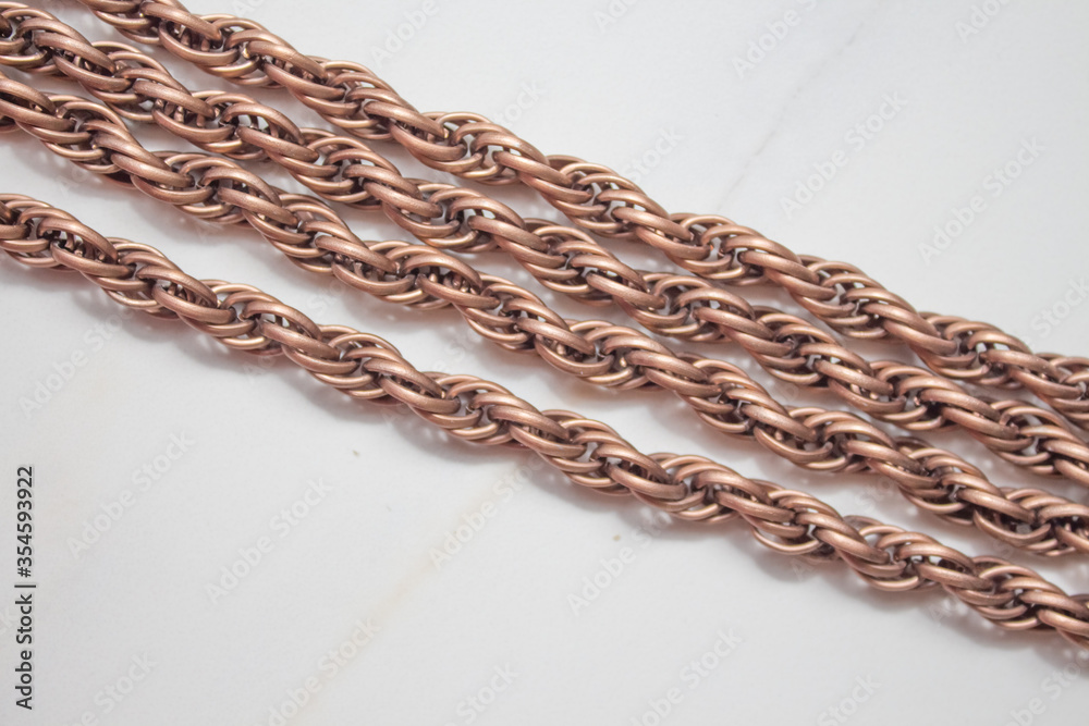 Fototapeta premium Decorative and jewelry gold chain close-up on a white background. Fashionable large chain