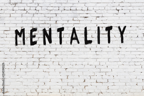 Word mentality painted on white brick wall
