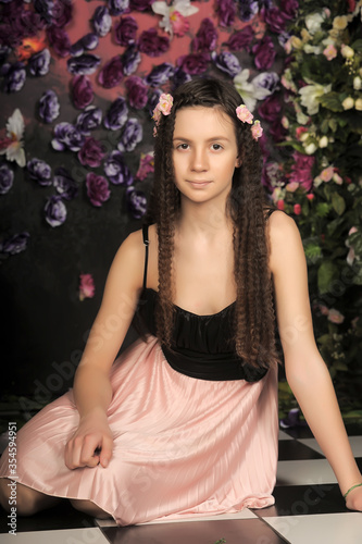 girl teenager brunette portrait with roses in hairstyle