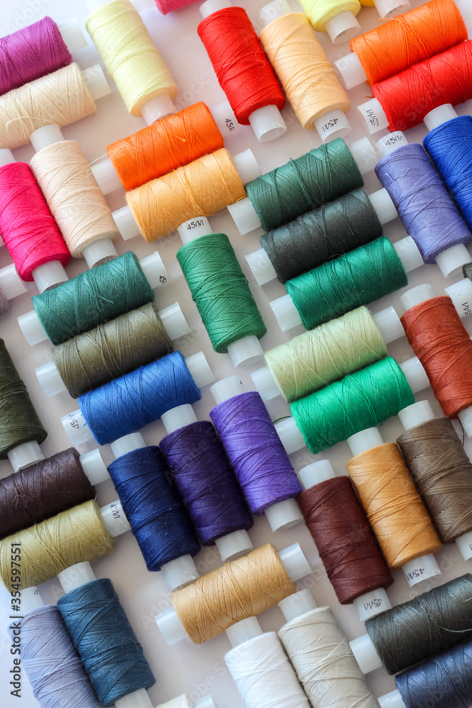 Close up of creative arrangement of colorful threads on a white background Close up of creative arrangement of colorful threads on a white background