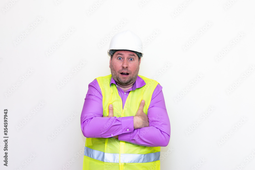 Curious crossed his arms about himself engineer makes all kinds of grimaces on a white background. Curious crossed his arms about himself engineer makes all kinds of grimaces on a white background.