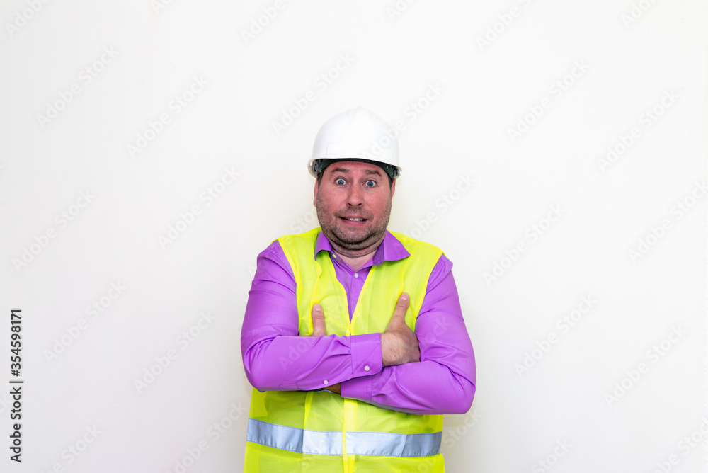 Curious crossed his arms about himself engineer makes all kinds of grimaces on a white background.